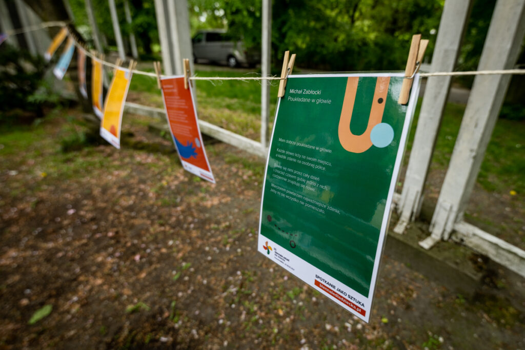 W parku miedzy drzewami rozwieszony jest sznurek. Na nim wiszą karki, przyczepione klamerkami.