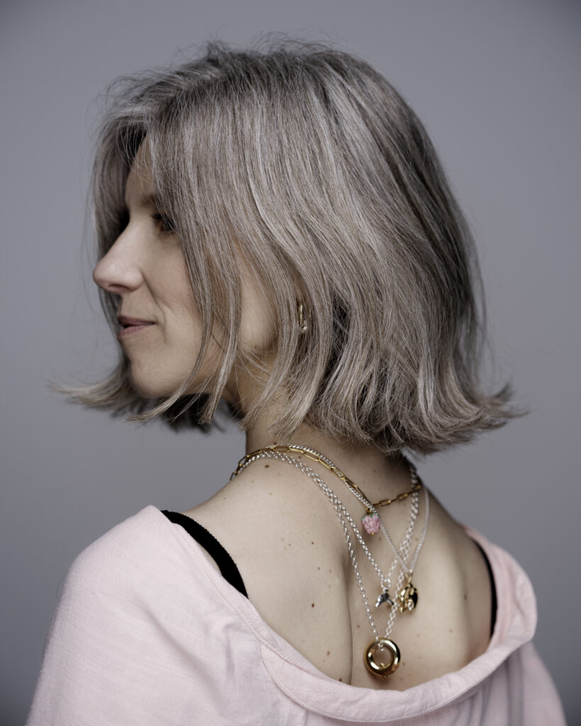 Kobieta odwrócona tyłem patrzy w dal.