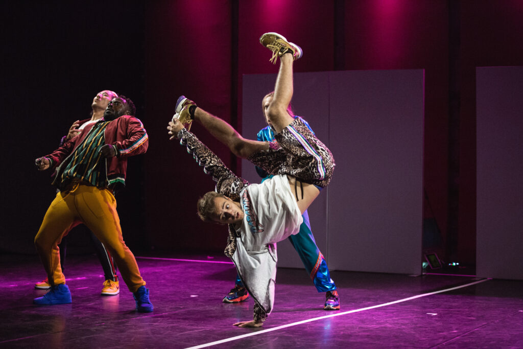 Dwoje tancerzy na scenie w tanecznych pozach.