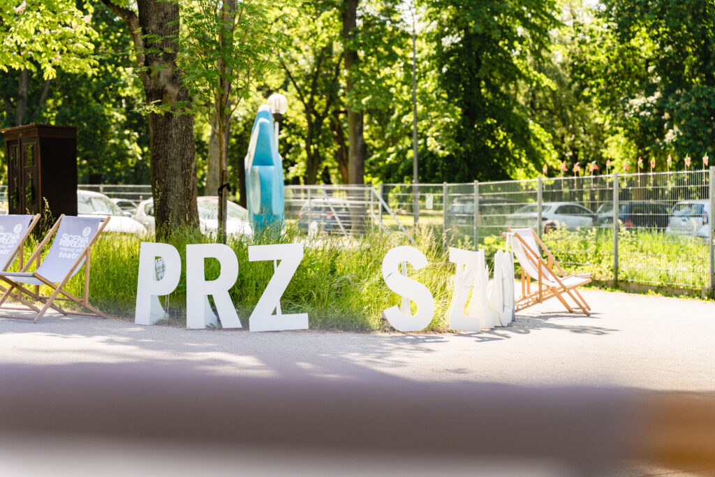 Widać rozłożony na ziemi napis: Prz...szłość.