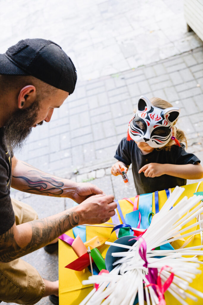 Dziecko przebrane w maskę kota. Obok niego mężczyzna.