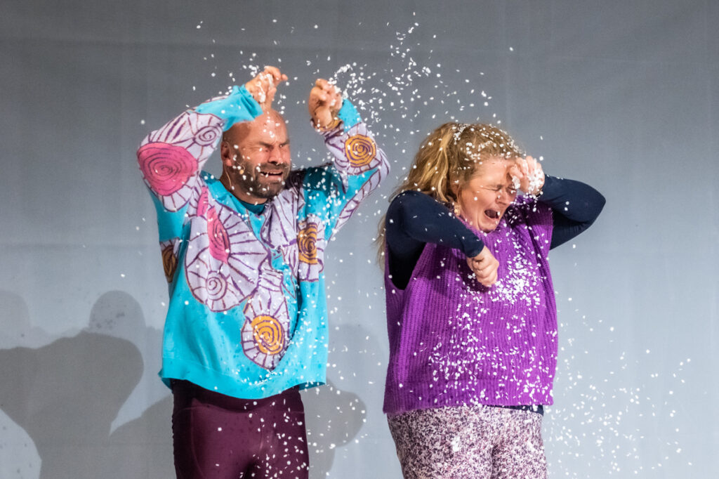Na scenie aktor i aktorka. Aktor zdaje się płakać a aktorka krzyczeć. Oboje rozrzucają styropianowe kulki.