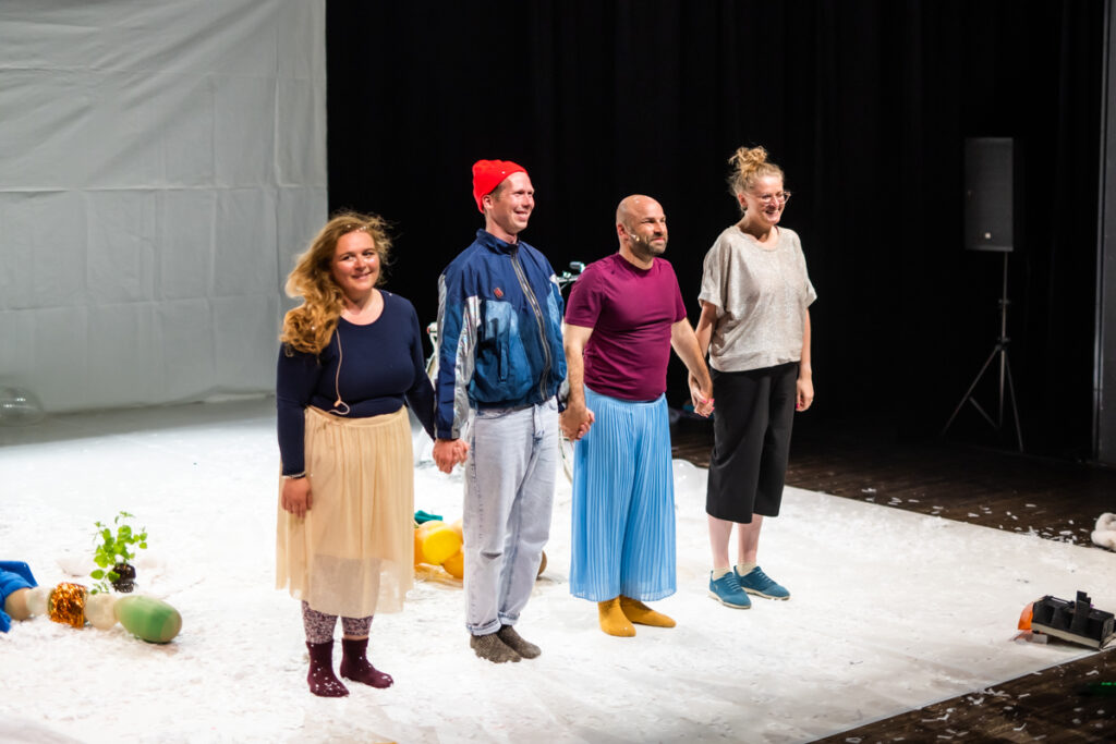 Na scenie czwórka aktorów spogląda w stronę widowni.