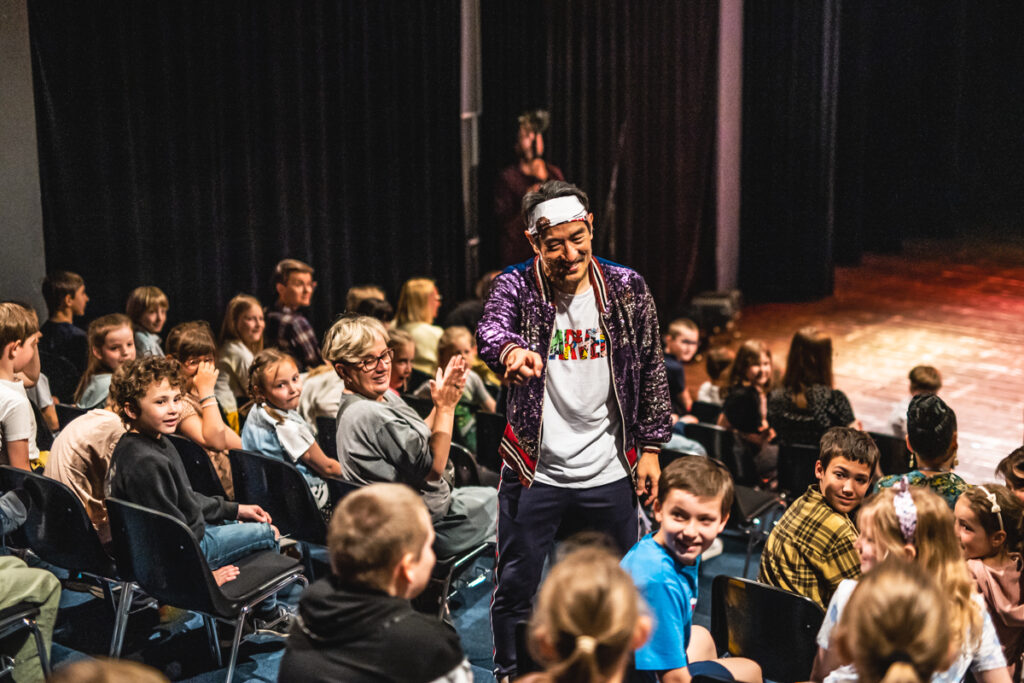 Aktor pośród widowni wskazuje palcem na wybraną osobę.