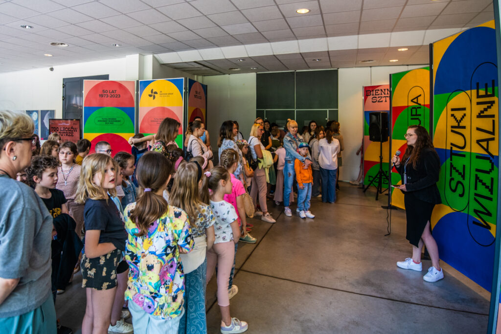 Grupa osób zgromadzony w holu wysłuchuje wystąpienia dyrektorki CSD.
