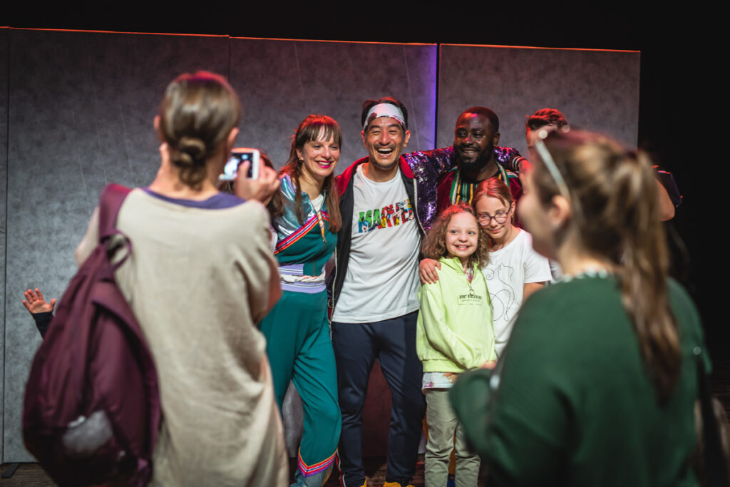 Grupa aktorów i dzieci pozują do zdjęcia.