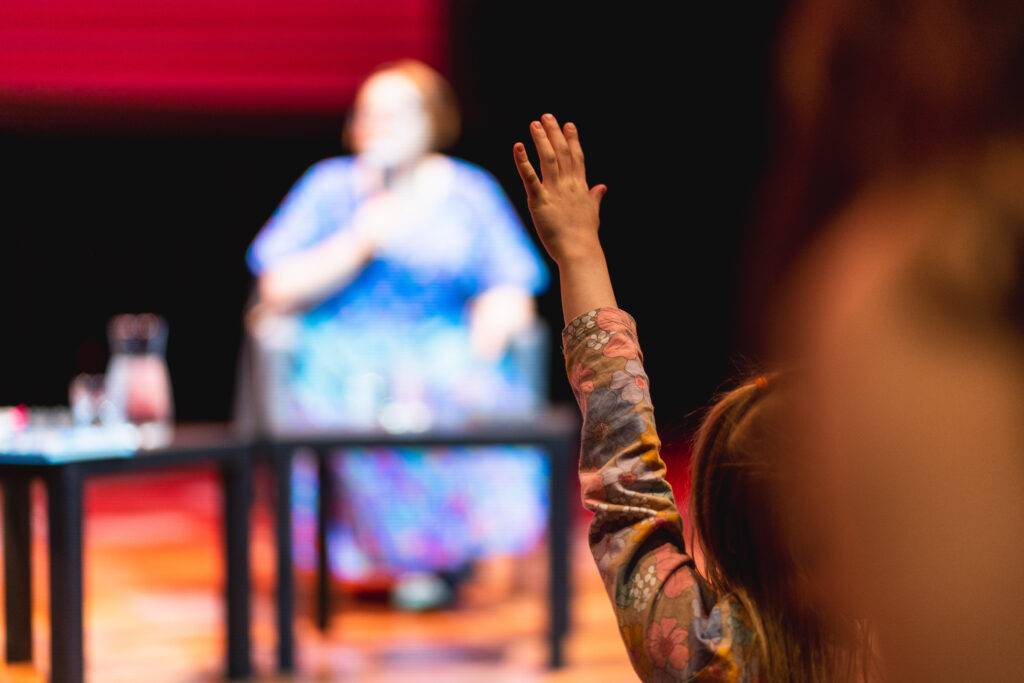 Dziecko ma wysoko uniesioną rękę.