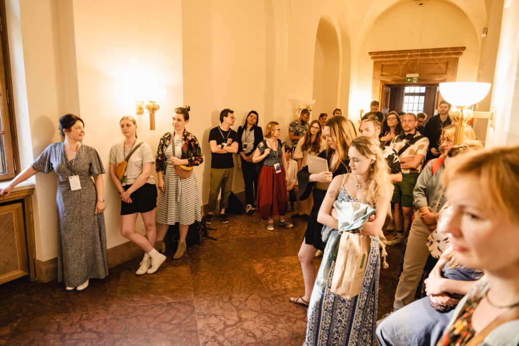 Grupa osób stoi w korytarzu poznańskiego Zamku.