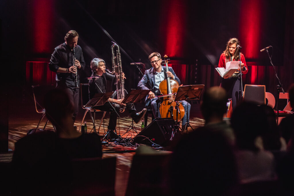 Na scenie grupa muzyków grająca na instrumantach.