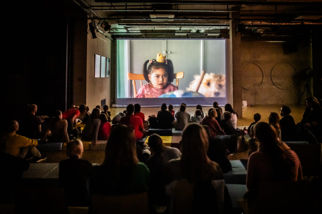 publiczność oglądająca na dużym ekranie plenerowym film