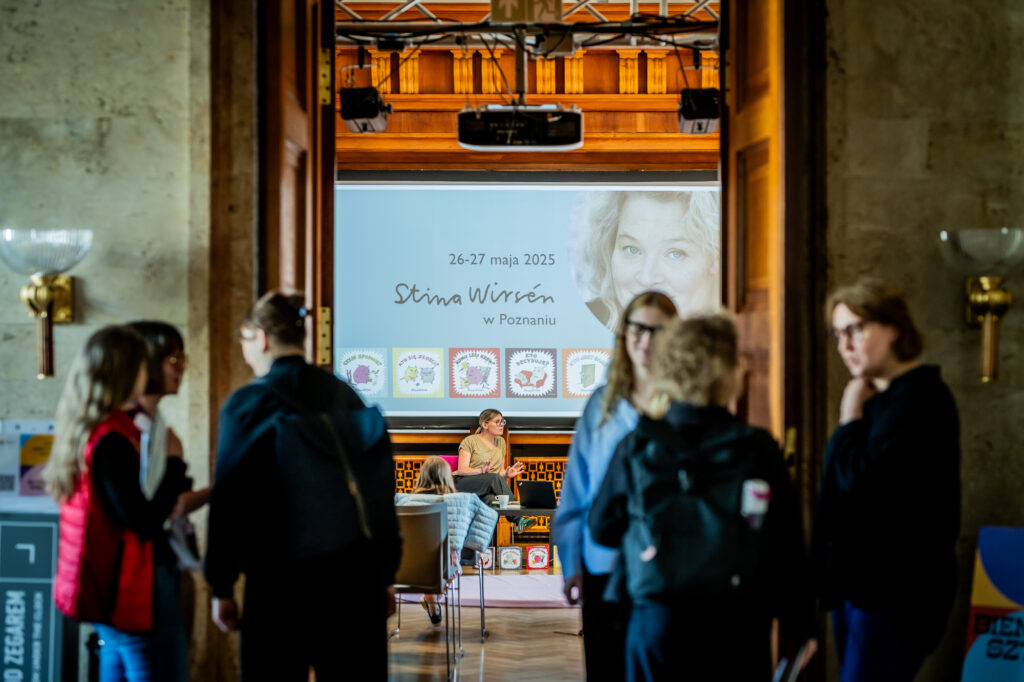 pięć osób przed wejściem do sali, w tle ekran z nazwą wydarzenia - spotkanie ze Stiną Wirsen