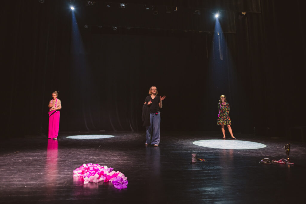 Trzy kobiety stoją na scenie i mówią