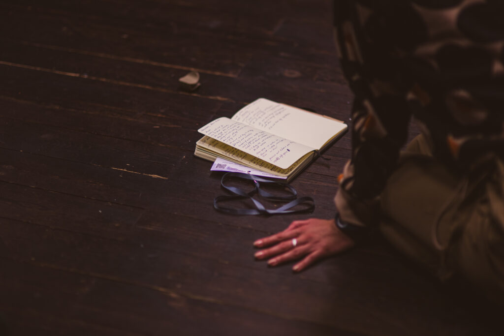 notes leżący na podłodze, obok niego kobieca dłoń